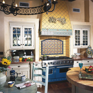 Ispirazione per una grande cucina tradizionale con ante con bugna sagomata, ante bianche, top in rame, paraspruzzi giallo, paraspruzzi con piastrelle in ceramica, elettrodomestici colorati, isola, lavello da incasso, parquet scuro e pavimento marrone