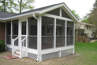 Inspiration for a mid-sized timeless screened-in back porch remodel in Other with decking and a roof extension