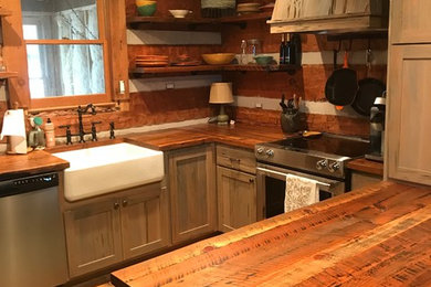 Small country u-shaped eat-in kitchen in Atlanta with a farmhouse sink, shaker cabinets, distressed cabinets, wood benchtops, brown splashback, timber splashback, stainless steel appliances, light hardwood floors, with island, brown floor and brown benchtop.