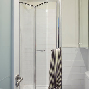 Inspiration pour une petite salle d'eau nordique avec un placard à porte vitrée, des portes de placard blanches, une douche double, un WC à poser, un carrelage blanc, des carreaux de céramique, un mur blanc, un sol en vinyl, un lavabo de ferme, un sol blanc et une cabine de douche à porte battante.