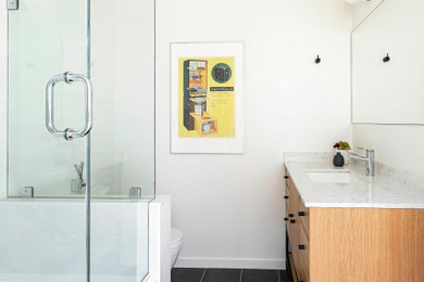 Inspiration for a small scandinavian white tile and ceramic tile gray floor and single-sink alcove bathtub remodel in Boston with flat-panel cabinets, light wood cabinets, a two-piece toilet, white walls, quartz countertops, white countertops, a niche and a freestanding vanity
