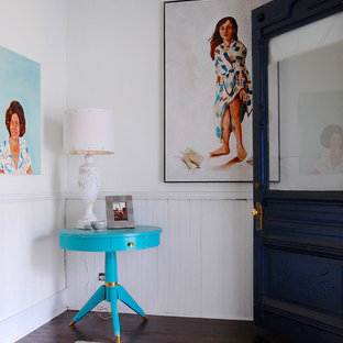 Exempel på en eklektisk entré, med vita väggar, mörkt trägolv, en enkeldörr, glasdörr och rött golv