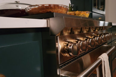 Danish medium tone wood floor eat-in kitchen photo in Minneapolis with an undermount sink, shaker cabinets, green cabinets, quartzite countertops, white backsplash, quartz backsplash, stainless steel appliances, an island and white countertops