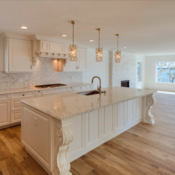 Grand Coastal Kitchen Island Showcases Carved Details And Light