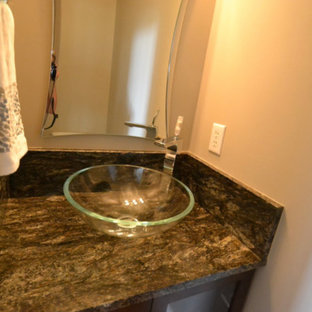 Ejemplo de aseo clásico renovado, pequeño, con armarios tipo vitrina, puertas de armario de madera en tonos medios, suelo de madera en tonos medios, lavabo sobreencimera, encimera de granito, suelo marrón y encimeras negras