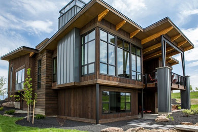 Example of a large trendy brown two-story wood flat roof design in Other