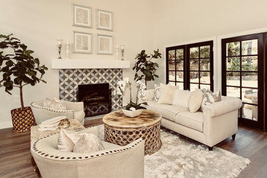 Example of a transitional medium tone wood floor and beige floor living room design in Orange County with a tile fireplace