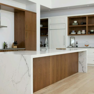 Large modern kitchen pantry inspiration - Inspiration for a large modern l-shaped light wood floor and beige floor kitchen pantry remodel in Phoenix with a farmhouse sink, flat-panel cabinets, medium tone wood cabinets, granite countertops, white backsplash, stainless steel appliances, an island and white countertops