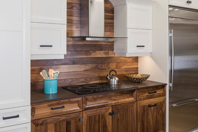 Inspiration for a mid-sized single-wall light wood floor and brown floor eat-in kitchen remodel in Boston with recessed-panel cabinets, medium tone wood cabinets, granite countertops, brown backsplash and stainless steel appliances