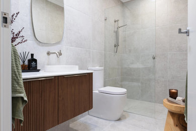 Design ideas for a mid-sized contemporary 3/4 bathroom in Sydney with medium wood cabinets, an open shower, a two-piece toilet, gray tile, a drop-in sink, solid surface benchtops, grey floor, an open shower, white benchtops, a niche, a single vanity and a floating vanity.