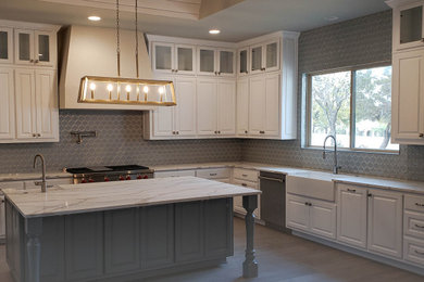 Eat-in kitchen - large contemporary l-shaped medium tone wood floor and gray floor eat-in kitchen idea in Austin with a farmhouse sink, flat-panel cabinets, white cabinets, quartz countertops, blue backsplash, glass tile backsplash, stainless steel appliances, an island and white countertops