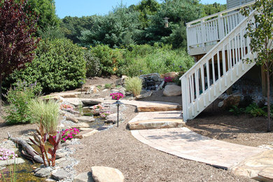 This is an example of a large traditional backyard stone water fountain landscape in Philadelphia.