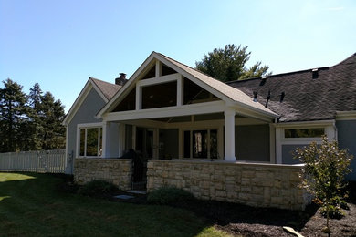 Large eclectic backyard stone patio photo in Columbus with a roof extension