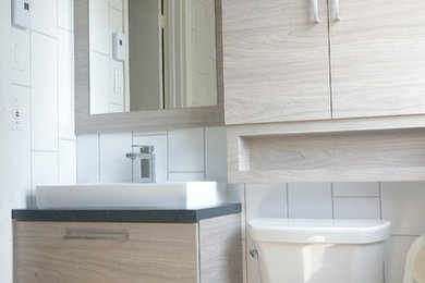 Inspiration for a contemporary white tile and porcelain tile porcelain tile and gray floor tub/shower combo remodel in Montreal with flat-panel cabinets, white walls and a trough sink