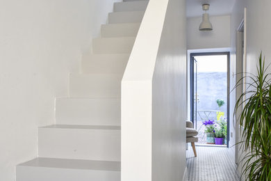 Inspiration for a small contemporary hallway in Dublin with white walls, ceramic floors and grey floor.