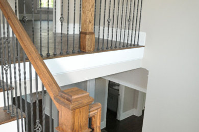 Mid-sized elegant wooden l-shaped metal railing staircase photo in Atlanta with painted risers