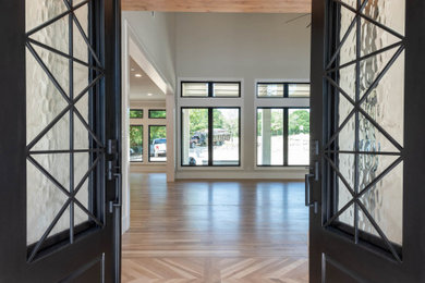 Example of a large classic light wood floor entryway design in Dallas with a black front door