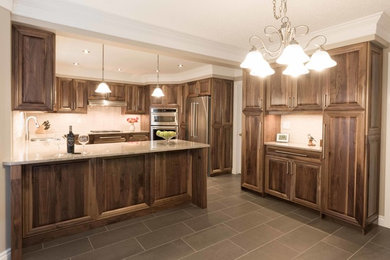 Large arts and crafts ceramic tile kitchen photo in Toronto with flat-panel cabinets, light wood cabinets, granite countertops, beige backsplash, ceramic backsplash, stainless steel appliances and a peninsula