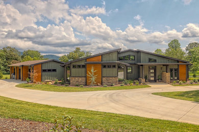 Example of a large mid-century modern green one-story mixed siding house exterior design in Atlanta with a shingle roof and a brown roof