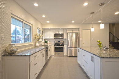 Large transitional l-shaped ceramic tile open concept kitchen photo in DC Metro with a drop-in sink, shaker cabinets, white cabinets, granite countertops, white backsplash, ceramic backsplash, stainless steel appliances and an island
