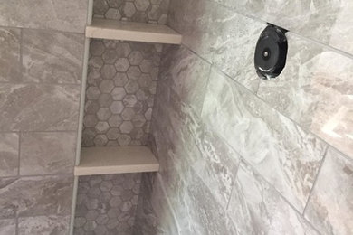 Foto de cuarto de baño moderno con ducha esquinera, baldosas y/o azulejos grises, baldosas y/o azulejos de porcelana, suelo negro y ducha con puerta con bisagras