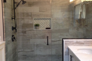 Elegant 3/4 gray tile and ceramic tile corner shower photo in New York with beaded inset cabinets, white cabinets, a drop-in sink, marble countertops, a hinged shower door and white countertops