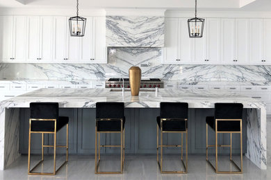 Example of a trendy l-shaped gray floor kitchen design in Orange County with an undermount sink, shaker cabinets, white cabinets, gray backsplash, stone slab backsplash, an island and gray countertops