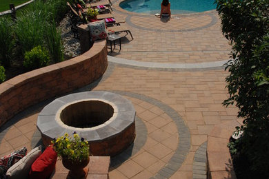 Design ideas for a mid-sized traditional backyard kidney-shaped natural pool in Philadelphia with a water feature and concrete pavers.