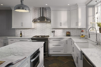 Inspiration for a large transitional l-shaped slate floor and multicolored floor enclosed kitchen remodel in Philadelphia with a farmhouse sink, recessed-panel cabinets, white cabinets, marble countertops, white backsplash, ceramic backsplash, stainless steel appliances and an island