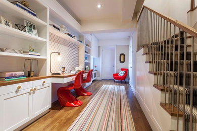 Inspiration for a mid-sized transitional built-in desk medium tone wood floor home office remodel in New York with white walls