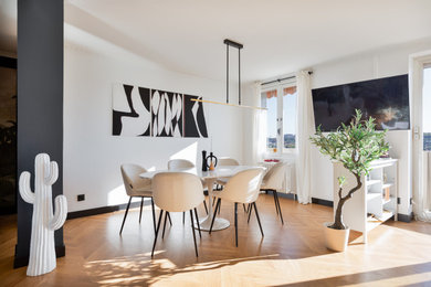 Exemple d'une salle à manger ouverte sur le salon éclectique de taille moyenne avec un mur blanc, sol en stratifié et un sol marron.