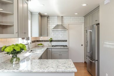 Photo of a small transitional eat-in kitchen in San Francisco with a double-bowl sink, shaker cabinets, grey cabinets, granite benchtops, white splashback, subway tile splashback, stainless steel appliances, medium hardwood floors and a peninsula.