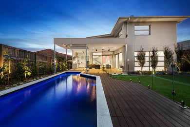 Contemporary backyard custom-shaped pool in Melbourne with decking.
