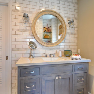 Coastal white tile brown floor bathroom photo in Los Angeles with shaker cabinets, gray cabinets, beige walls, an undermount sink and white countertops