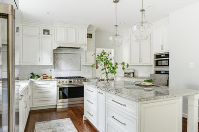 Mid-sized elegant u-shaped medium tone wood floor and brown floor open concept kitchen photo in DC Metro with a double-bowl sink, recessed-panel cabinets, white cabinets, granite countertops, gray backsplash, marble backsplash, stainless steel appliances, an island and multicolored countertops