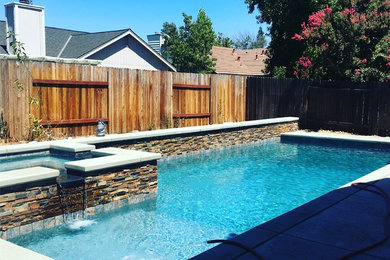 Mid-sized elegant backyard rectangular natural pool fountain photo in Sacramento with decking