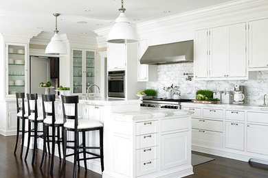 Kitchen - large traditional dark wood floor kitchen idea in New York with white cabinets, marble countertops, white backsplash, subway tile backsplash, stainless steel appliances and an island