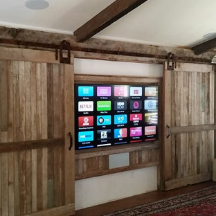 Photo of a rural enclosed home cinema in San Francisco with multi-coloured walls, dark hardwood flooring, a built-in media unit and brown floors.