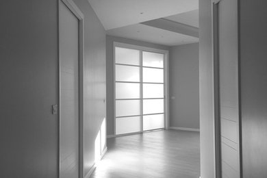 Immagine di un corridoio minimal di medie dimensioni con pareti beige, pavimento in gres porcellanato e pavimento beige