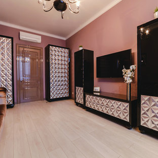 Aménagement d'une salle de cinéma éclectique de taille moyenne et ouverte avec un mur rose, un sol en bois clair, un téléviseur fixé au mur et un sol beige.