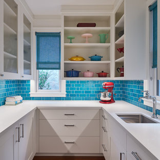 Exemple d'une arrière-cuisine tendance en U de taille moyenne avec un évier encastré, un placard sans porte, des portes de placard blanches, une crédence bleue, une crédence en carrelage métro, un sol en bois brun, un plan de travail blanc, un plan de travail en surface solide et un sol marron.