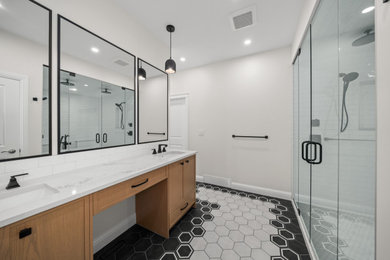 Example of a large transitional master white tile and ceramic tile ceramic tile, black floor and double-sink bathroom design in Calgary with flat-panel cabinets, light wood cabinets, a two-piece toilet, white walls, an undermount sink, quartz countertops, a hinged shower door, white countertops and a built-in vanity