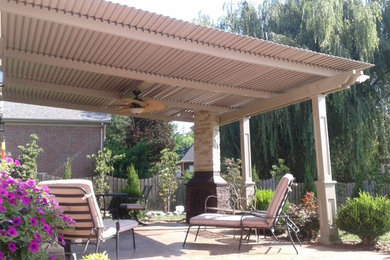 Photo of a mid-sized courtyard patio in Boston with a fire feature, concrete slab and a pergola.