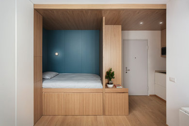 Immagine di una piccola camera da letto etnica con parquet chiaro, soffitto in legno e pannellatura