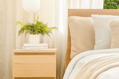 Foto de habitación de invitados de tamaño medio sin chimenea con paredes beige, suelo de madera clara y suelo marrón