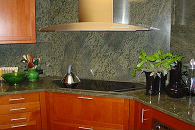 Example of a mid-sized u-shaped kitchen design in Chicago with shaker cabinets, medium tone wood cabinets, granite countertops, green backsplash, stone slab backsplash, stainless steel appliances and no island