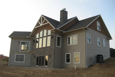 Example of a large classic gray two-story mixed siding exterior home design in Other with a shingle roof