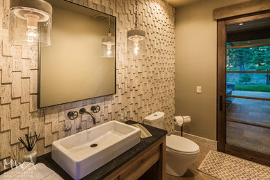 This is an example of a mid-sized contemporary powder room in Other with open cabinets, medium wood cabinets, a two-piece toilet, beige tile, brown walls, a vessel sink, slate, beige floor and black benchtops.