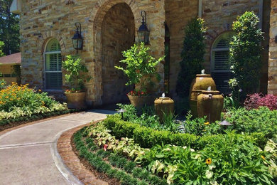 Design ideas for a mid-sized traditional full sun front yard brick landscaping in Houston for summer.