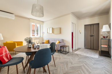 Immagine di una sala da pranzo aperta verso il soggiorno boho chic con pareti beige, pavimento in laminato e pavimento beige